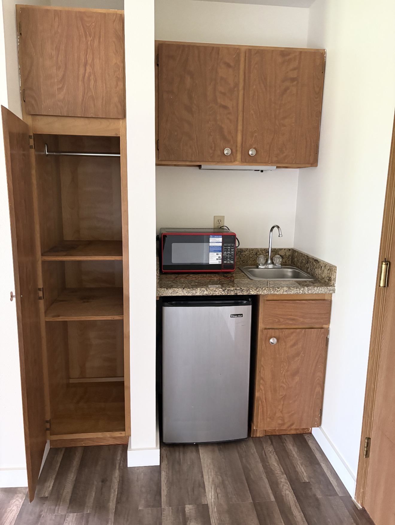 Private apartment kitchenette with sink, refrigerator, microwave and storage