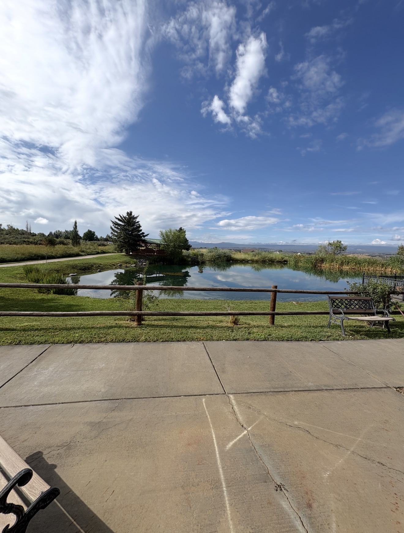 Concrete walking path beside the pond with mountain views